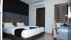 Une chambre d’hôtel moderne, dotée d’un grand lit, d’un bureau et d’une chaise.