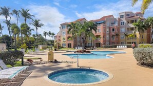 A resort with multiple swimming pools, palm trees, and a building with balconies. - Spacious 3BR apt for 10 Guests | Palmas del Mar (Palmas Del Mar)