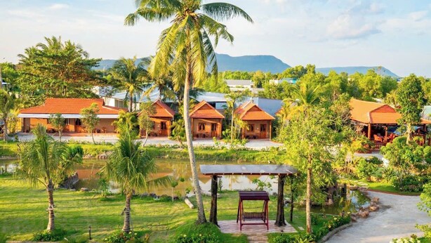 A resort with multiple bungalow-style buildings, a central water feature, and lush greenery. - New Serene (Phu Quoc)