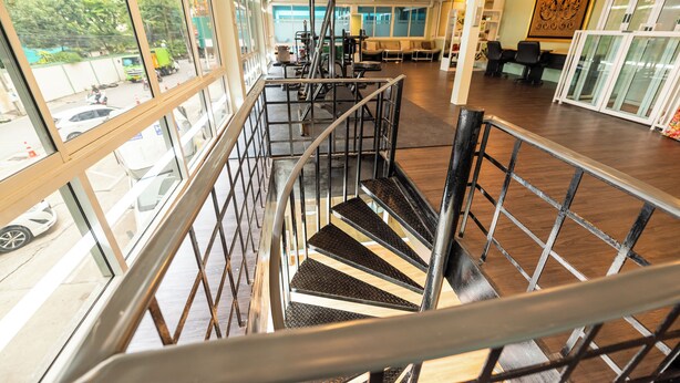 A multi-level interior with a staircase, large windows, and a seating area.