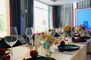 A dining table set for a meal with wine glasses, plates, and flowers. - Julan'an Homestay (Guilin Liangjiang Sihu Dongxi Alley Shop) (Guilin)