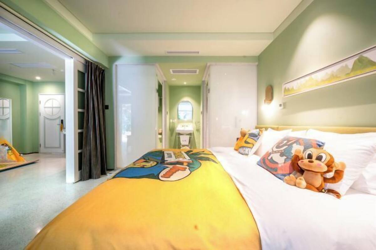 A hotel room with a bed, a window, and a door.