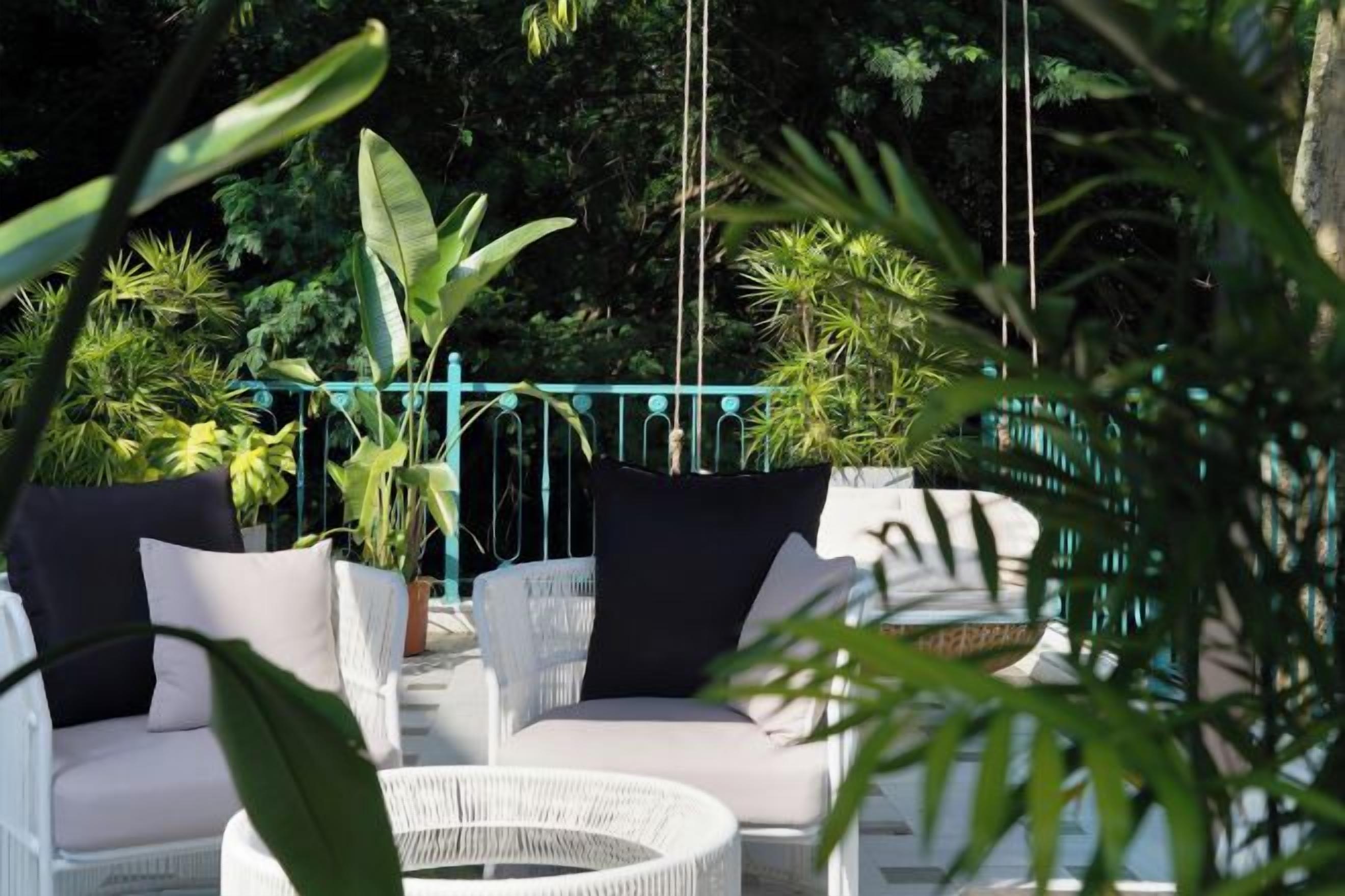 A patio area with wicker furniture and potted plants.