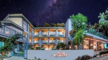 A hotel with a prominent sign, multiple balconies, and a night sky with visible stars.