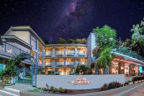 A hotel with a prominent sign, multiple balconies, and a night sky with visible stars.