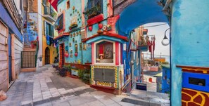 A narrow street with colorful buildings, a small shop, and a blue archway. - B&B Le Maioliche (Vietri sul Mare)