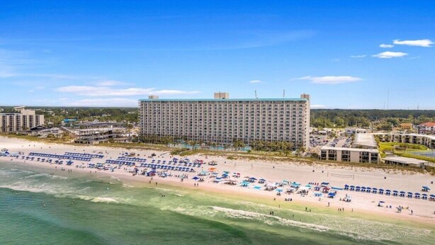 A coastal hotel with a large building, beach with sun loungers, and a view of the ocean. - Summit Gulf Front Unit 421 | 4th Floor (Panama City Beach)