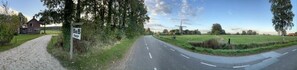 A rural road with a B&B sign, a gravel path, and a field. - B&B Zwiep (Lochem)