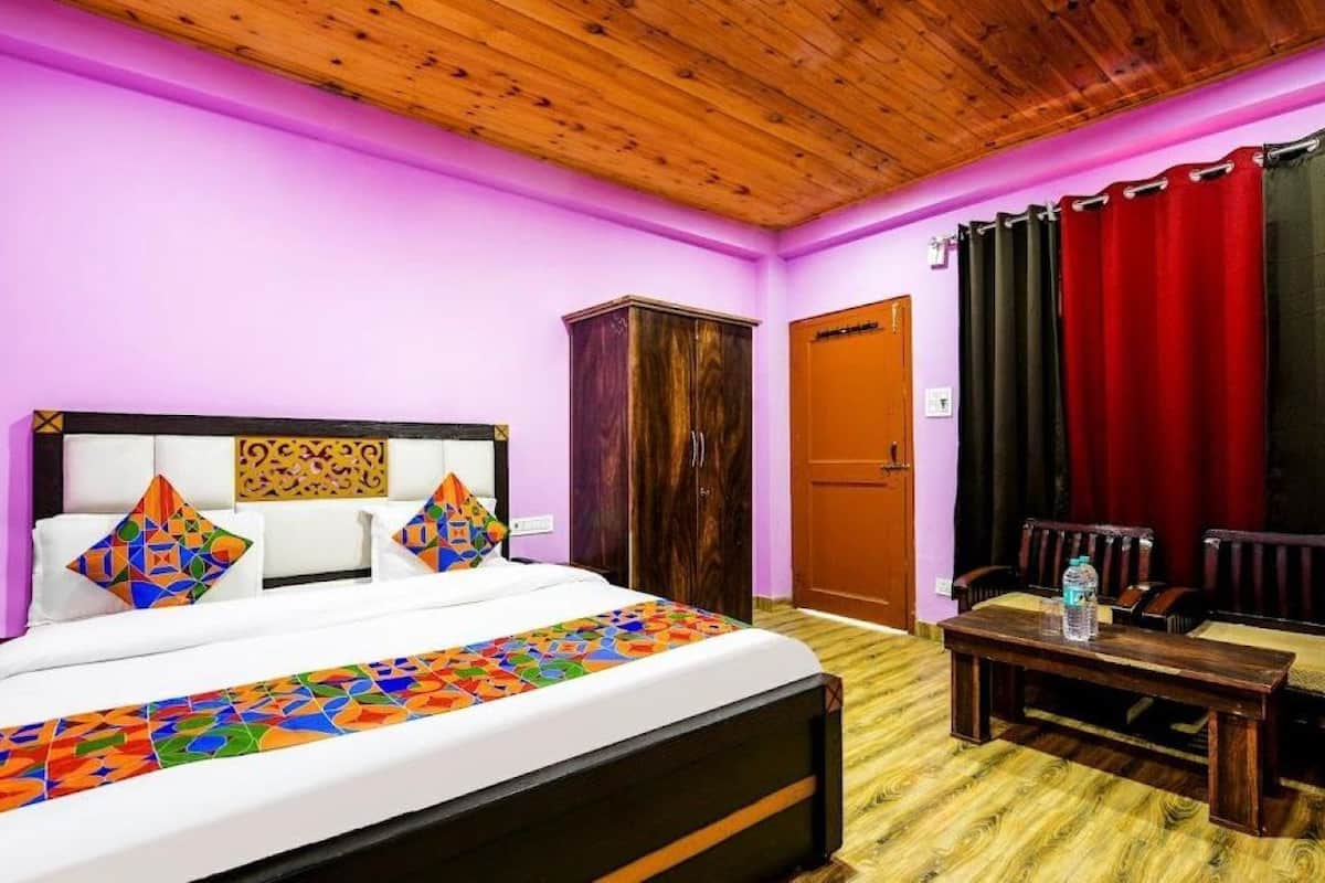 A bedroom with a bed, a wooden headboard, a wooden wardrobe, a red curtain, and a wooden bench.