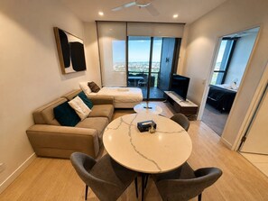 Un salon moderne avec un canapé, une table ronde et un téléviseur.