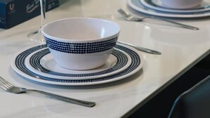 A dining table set with white plates, blue patterned bowls, and silverware. - High-Value 4Beds | Workspace | Near Mall & Highway (Macgregor)