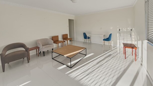 A modern living room with a sofa, chairs, a coffee table, and a dining table. - Practical 2BR Stay at a Great Price Well-Located (Robertson)