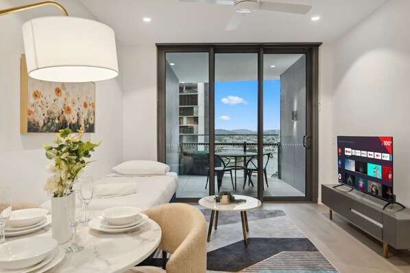 A modern living room with a sofa, dining table, and TV.