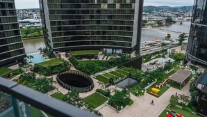 Un ensemble immobilier moderne comprenant un patio central, une piscine et une vue sur la rivière.
