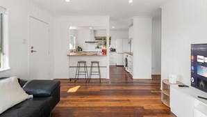 A modern apartment with a kitchen, dining area, and living room. - 3Beds Value & Comfort Stay | Airport, CBD & Cafes (Bulimba)