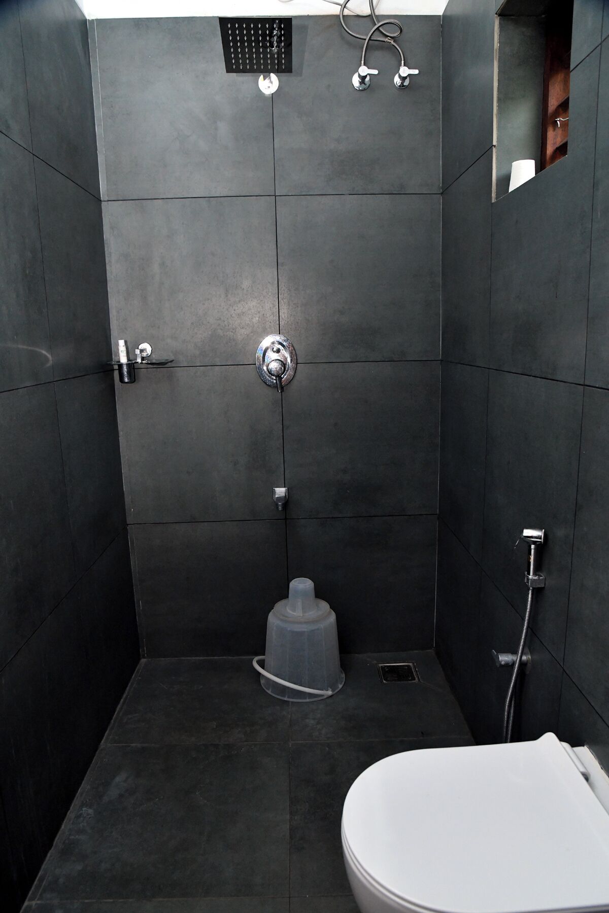 A modern bathroom with a shower, toilet, and a small sink.