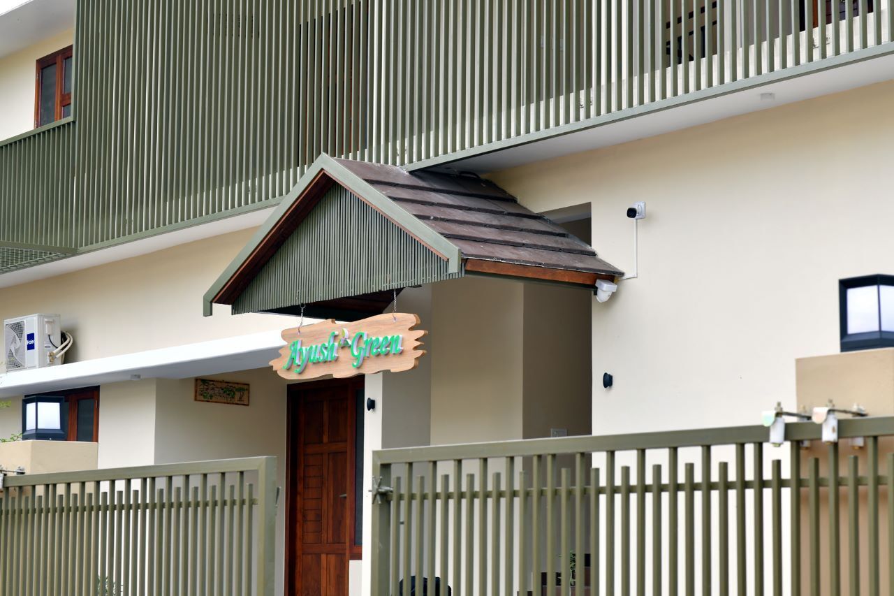 A building with a green facade, a wooden door, and a sign that reads "Just Green".