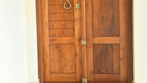 Puerta doble de madera con dos pomos verticales y un cerradura central.
