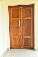 Puerta doble de madera con dos pomos verticales y un cerradura central.