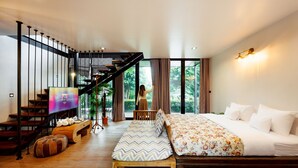 A modern bedroom with a large bed, a wooden bench, a TV, and a staircase leading to a balcony. - Oxy Resort Chiangrai (Mae Chan)