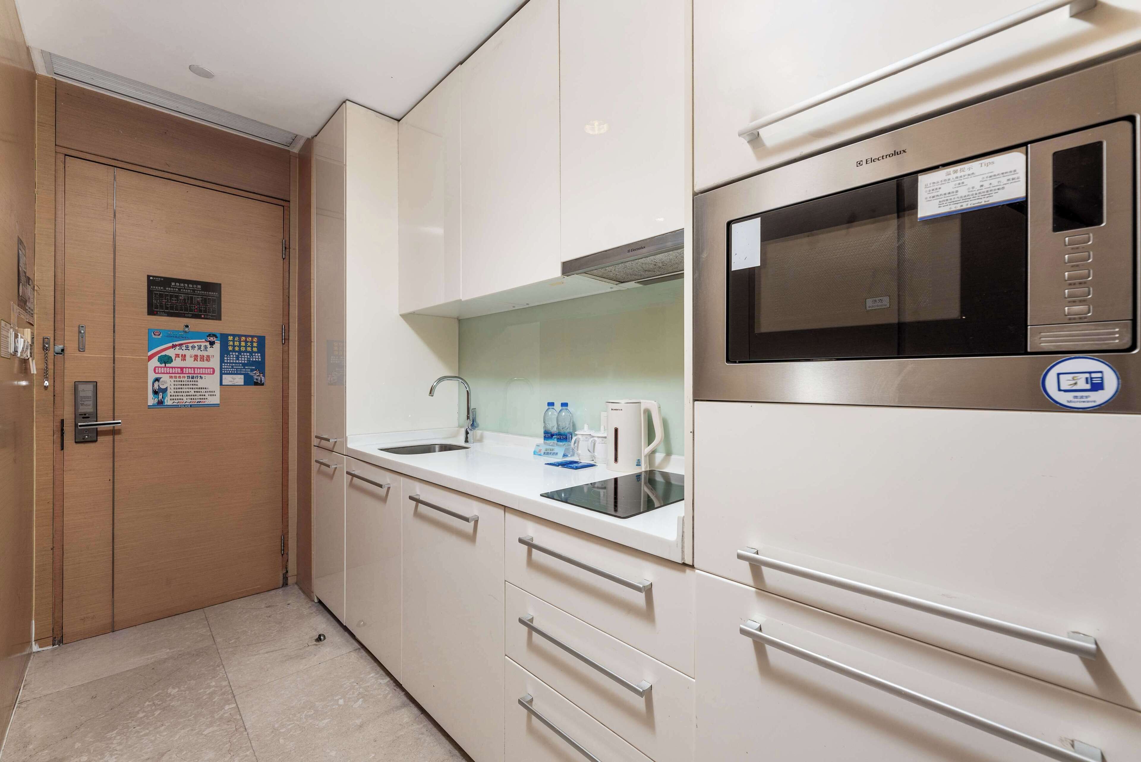 A modern kitchen with stainless steel appliances, a microwave, and a sink. There are cabinets and drawers for storage.