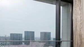 Vista desde un edificio alto, con un río y vegetación abajo, y varios edificios más a lo lejos.