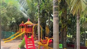 A playground with slides and climbing structures surrounded by palm trees. - Savali Resort (Diveagar)