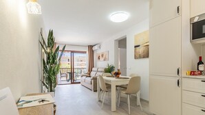 Um apartamento moderno com área de refeições, cozinha e varanda com vista.