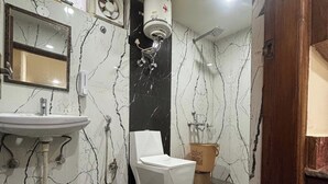A bathroom with a white toilet, a sink, and a shower. - Jakhu heights (Shimla)