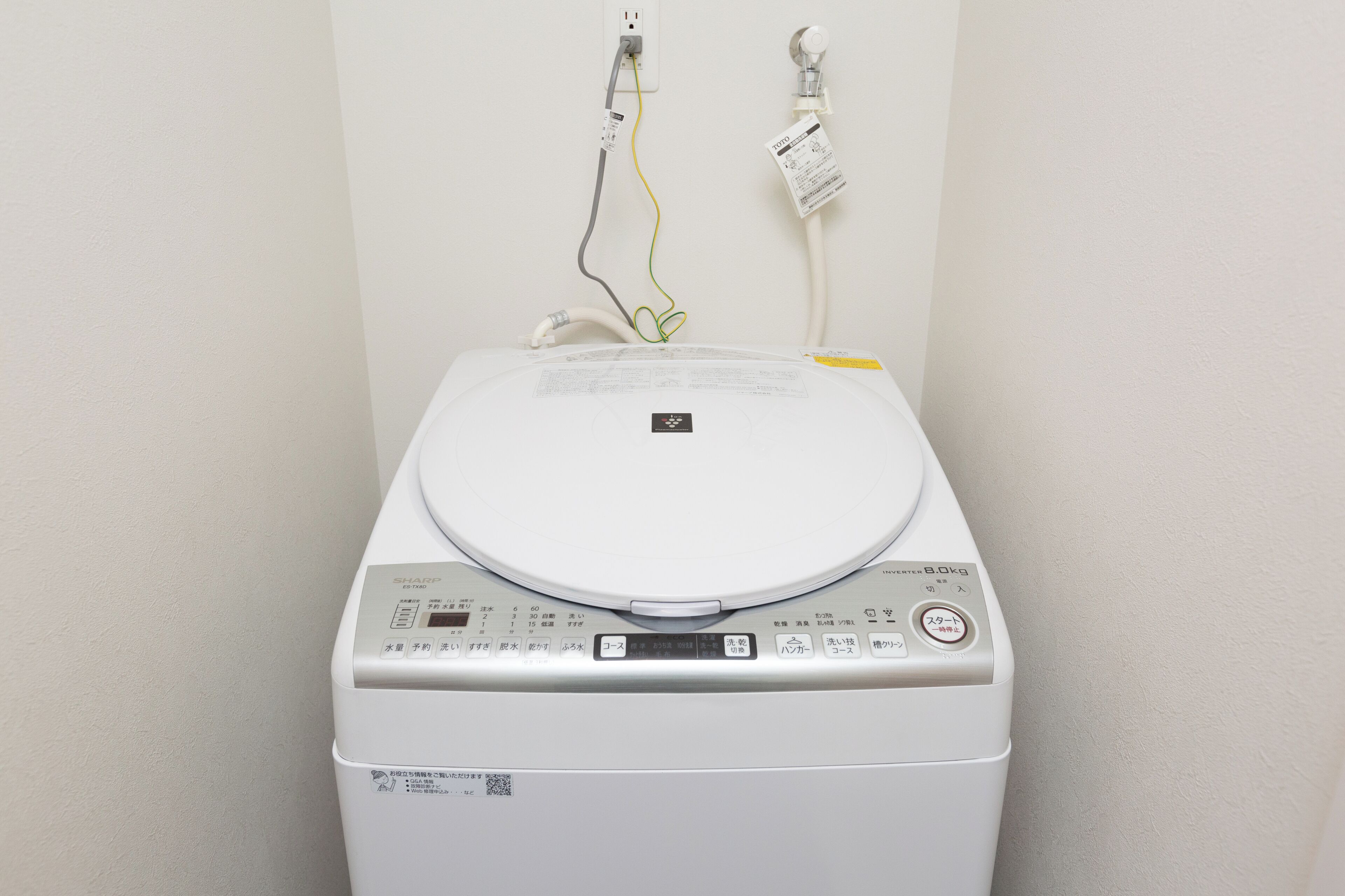 A white washing machine with a control panel and a label on the front.