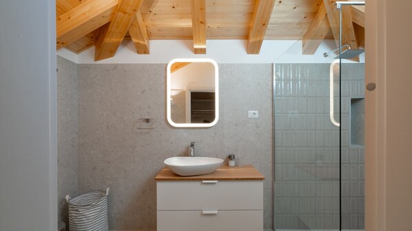 A modern bathroom with a wooden ceiling, a white sink, a mirror, and a shower with a patterned glass door. - Villa Lipovac by Villas Guide (Blato)