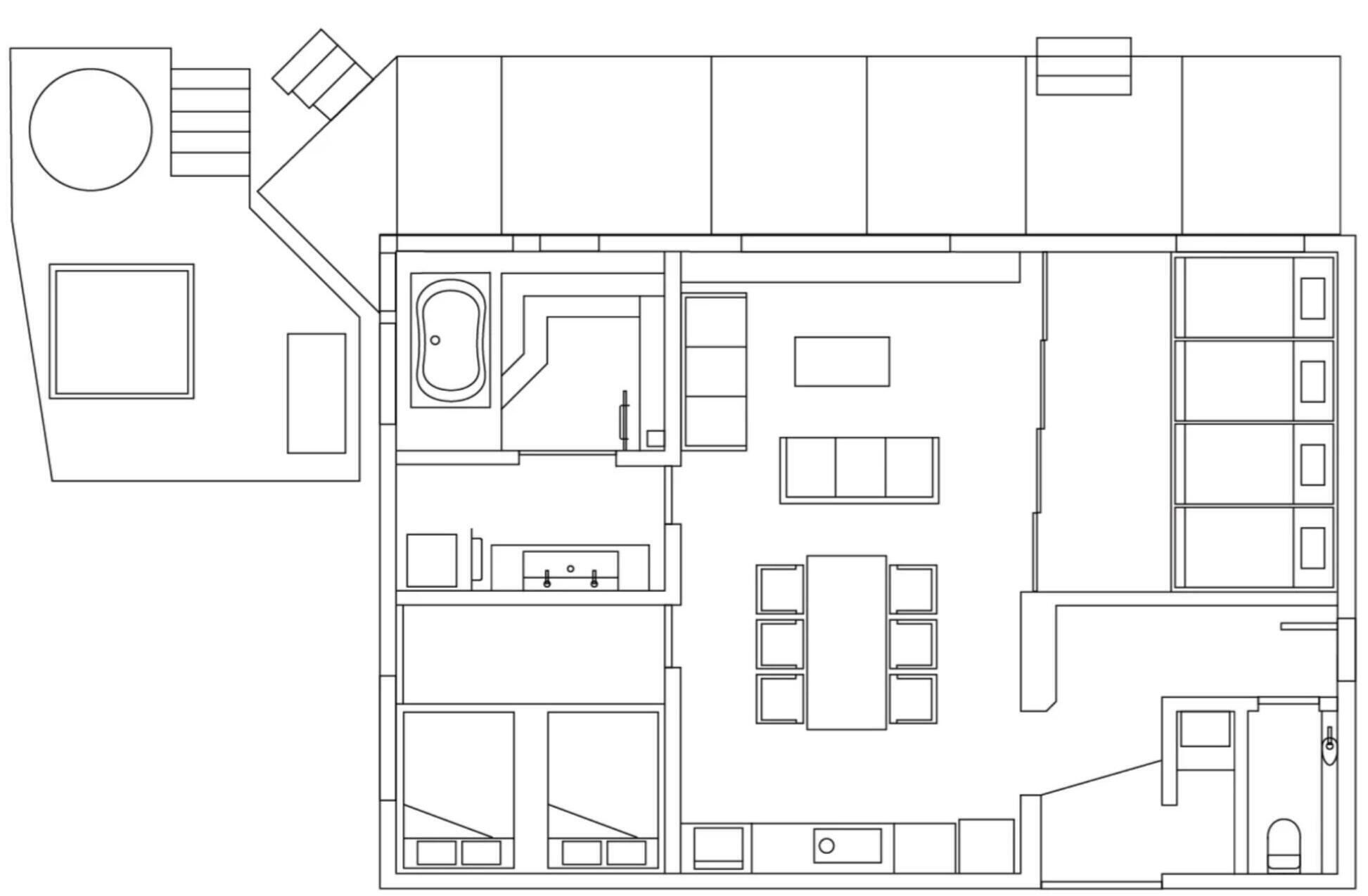 Plano de planta que muestra una zona de estar central, una cocina, un comedor y un baño.
