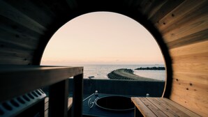 A circular wooden structure with a bench and a bicycle, overlooking a beach and ocean. - UMITOMA OCEAN VIEW RESORT ECHIZEN (Fukui)