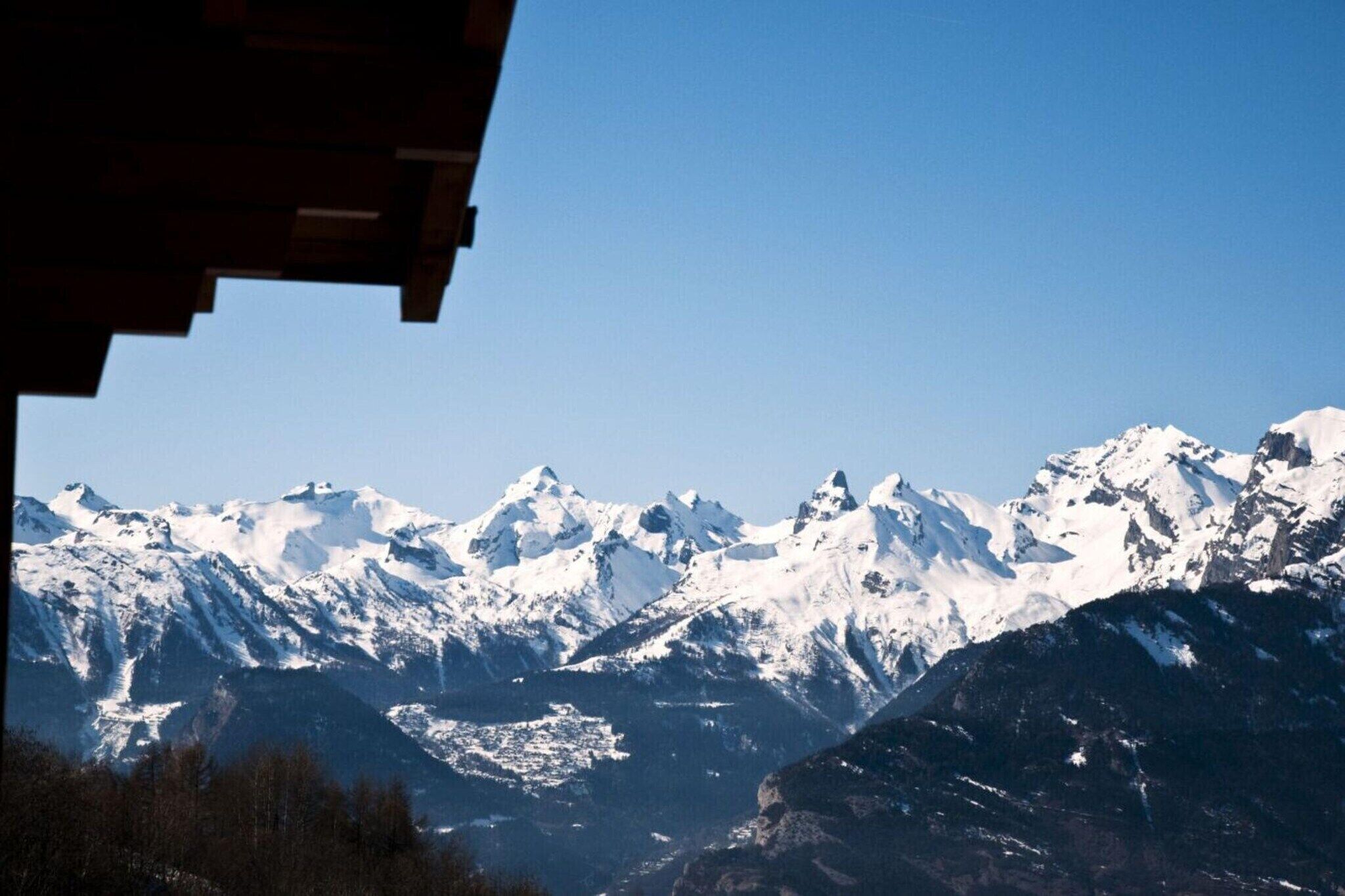 Een bergketen met besneeuwde toppen en een heldere lucht.