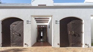 A building with three arched doors, numbered 30, 31, and 32, leading to a covered entrance. - Winelands Golf Lodges 29 (Cape Town)
