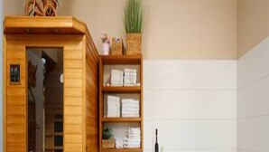 Een sauna met een houten kast, een witte stoel en een whirlpool.
