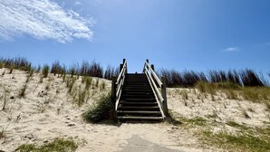 A wooden staircase leading up a sandy beach with dunes and grass. - Beach House Westkapelle 105.1 by Interhome (Westkapelle)