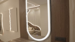 A bathroom with a wooden vanity, a mirror with integrated lighting, and a modern design. - Villa Vistosa Omaxe Hazratganj (Lucknow)