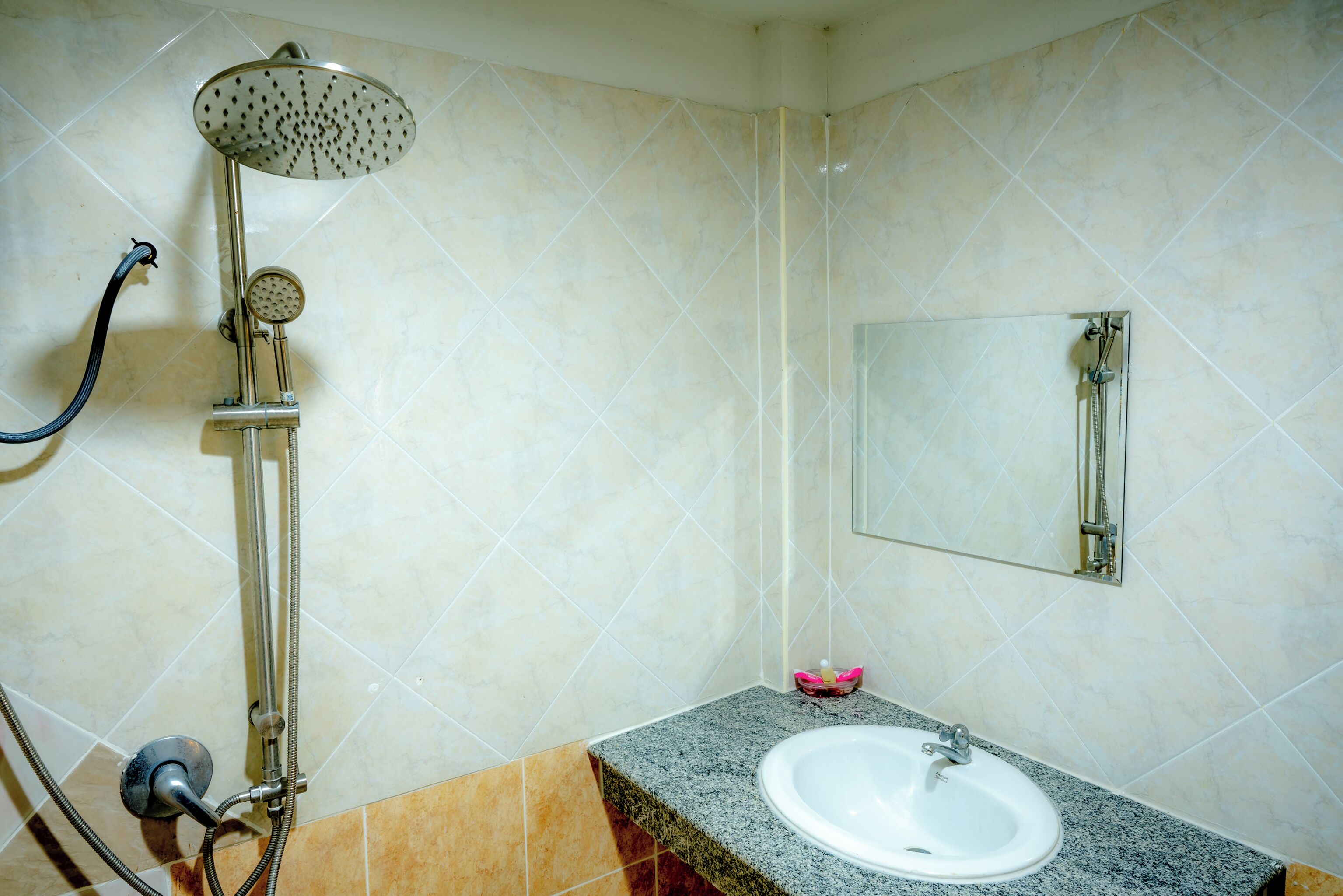 A bathroom with a shower, sink, and mirror.
