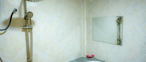 A bathroom with a shower, sink, and mirror.