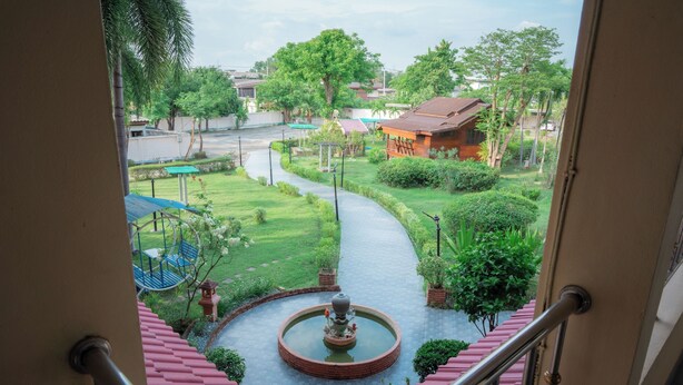 A view from a balcony with a fountain, a curved pathway, and surrounding greenery. - Kohloy Golden Park (Tak)