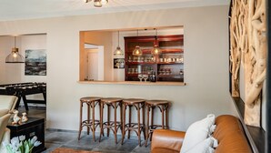 Uma sala de estar moderna com mesa de futebol, banquetas de bar e um espaço para sentar.