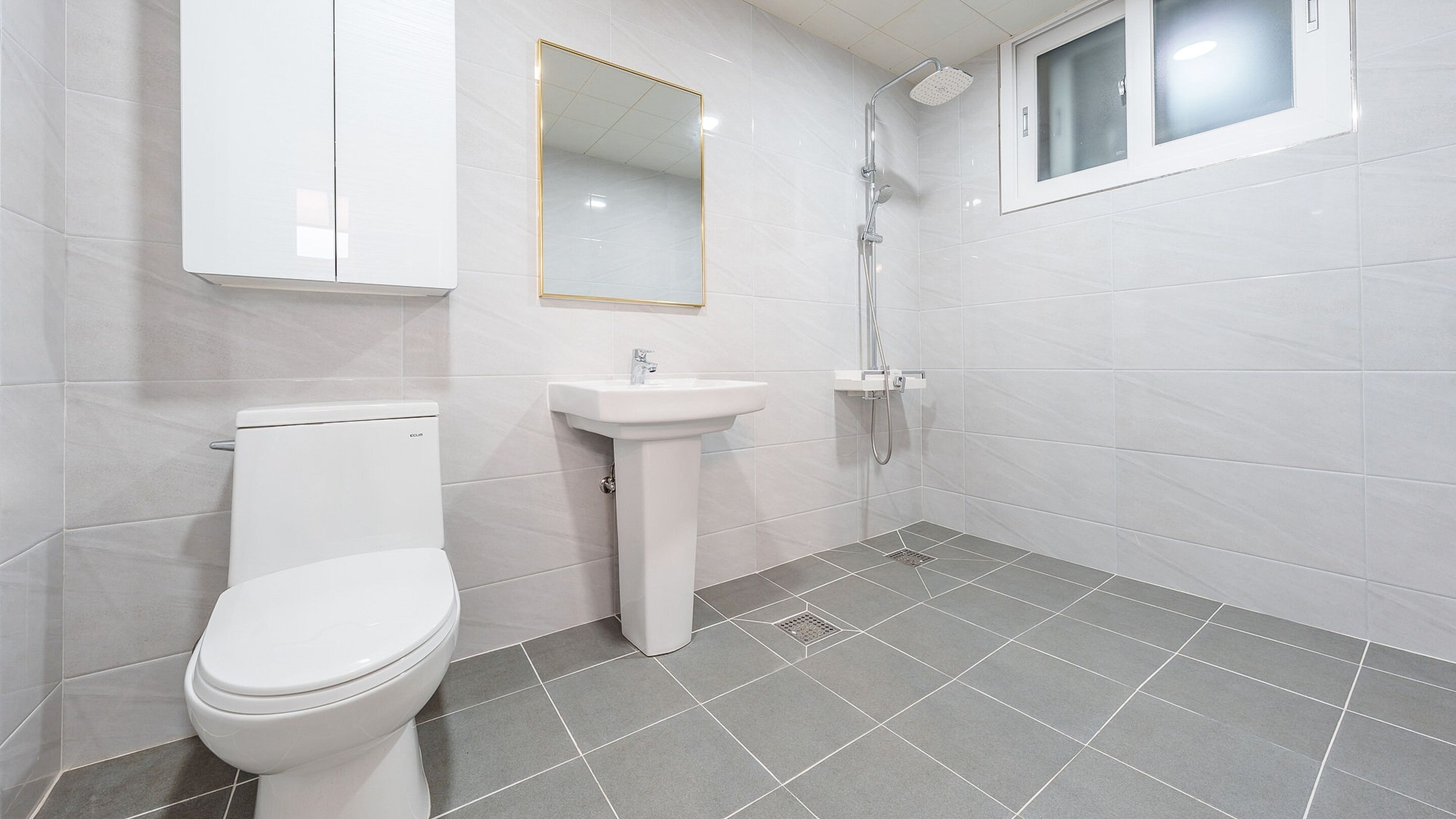 Un baño con inodoro, lavamanos y ducha.