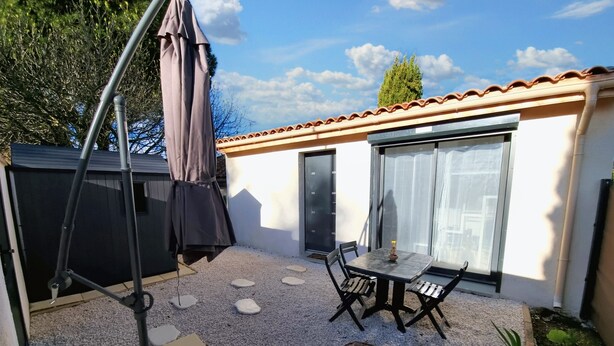 A patio with a swing set, a table and chairs, and a small garden area. - Cosy, fully-equipped Tiny House - private garden (Castanet-Tolosan)