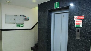 An elevator with a 'No Smoking' sign, a fire exit sign, and a number '1' indicating the floor. - Sai Nalam Guest Inn (Chennai)