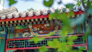 Un edificio tradicional chino con tejas ornamentales y murales coloridos.