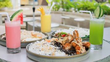 A table with a variety of dishes including rice, fried chicken, and drinks.