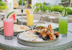 A table with a variety of dishes including rice, fried chicken, and drinks.