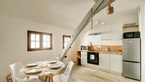 A modern kitchen with white cabinets, a stainless steel refrigerator, and a wooden countertop. - Le Belvédère: A meeting place for friends (Tours)