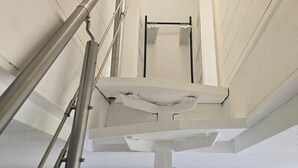 Ett vitt tak med en metalltrappa och ett svart element.